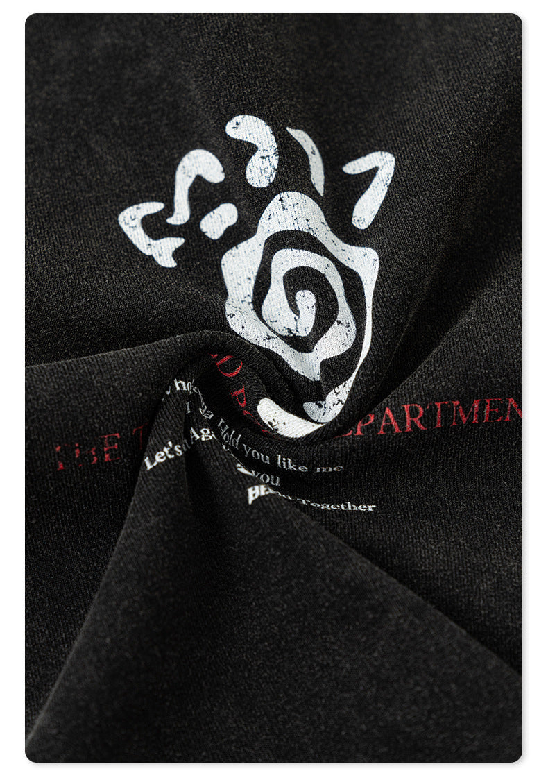 Close-up of the black T-shirt fabric twisted to reveal a white and red distressed graphic print