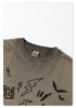 Close-up of taupe t-shirt collar detail showing New Wave Street Culture tag and distressed edge finish