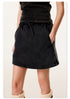 Close-up view of black mini skirt showing drawstring waist detail and comfortable fit against white background