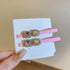 Pink alligator clips with double rectangular faceted crystals, surrounded by rhinestones, displayed on a card.