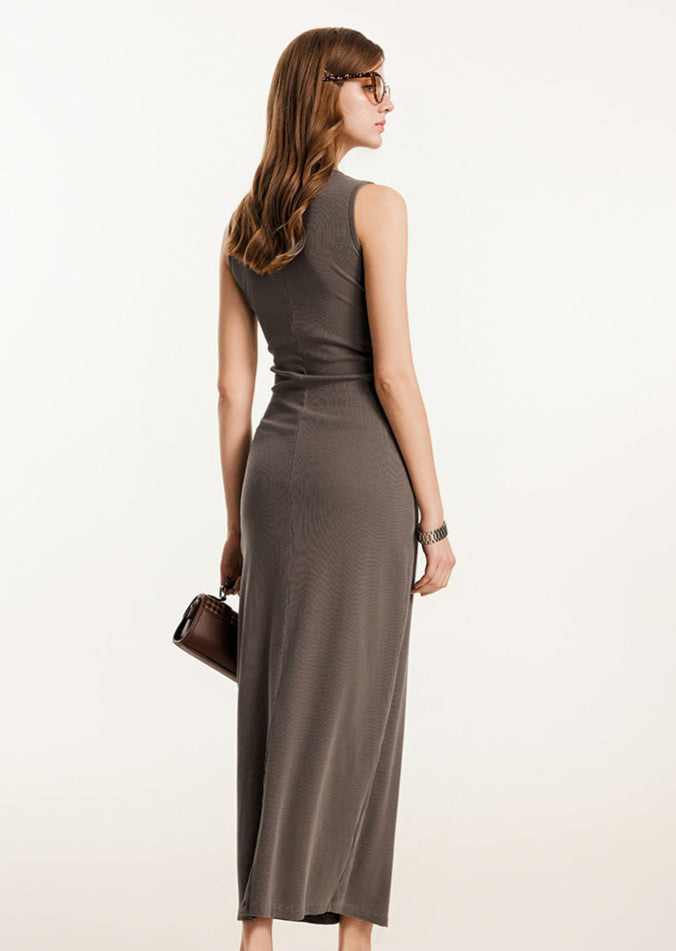Rear view of brown ribbed bodycon maxi dress, highlighting the fit and fabric texture, accessorized with a brown handbag.