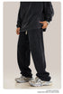 Side profile of black sweatpants with white drawstring, showing detailed panel stitching and relaxed fit