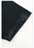 Close-up of black Backstairs sweatpants fabric showing distressed paint-splatter pattern and textile texture