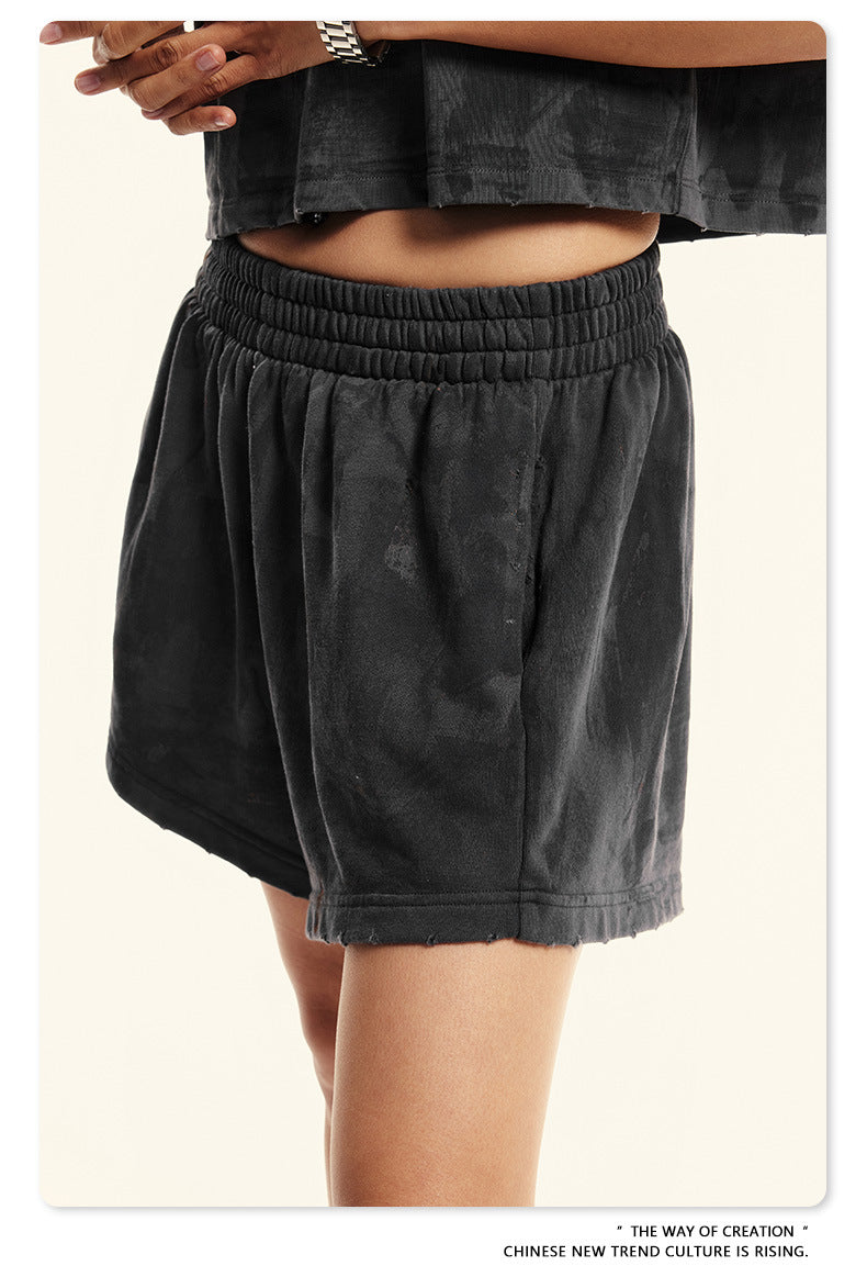 Close-up of black washed shorts with elastic waistband showing texture detail and silver watch