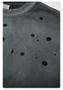Detailed view of black paint splatter pattern on gray sweatshirt fabric