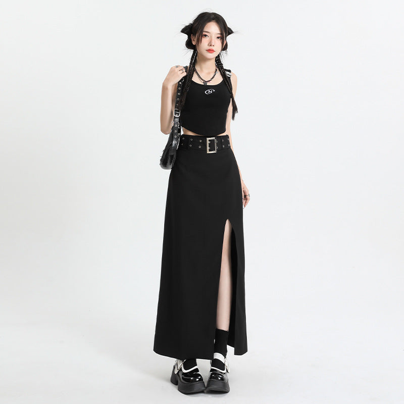 Model wearing black tank top and maxi skirt with silver belt detail, styled with platform shoes against white backdrop