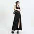 Front view of black maxi ensemble with crop top, studded belt and side slit skirt, accessorized with necklace