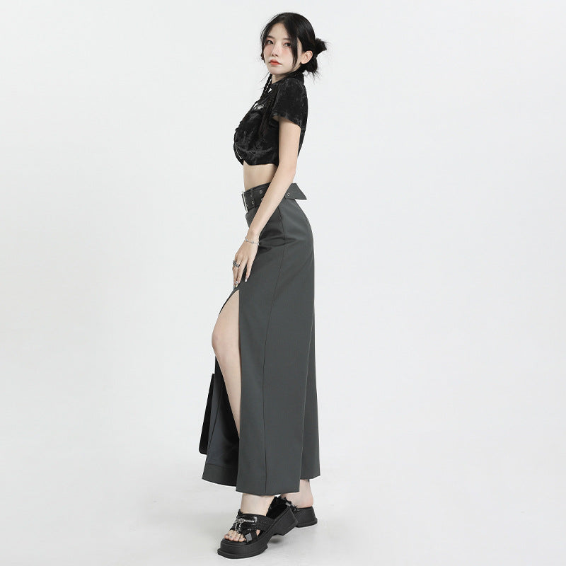 Side profile of gray maxi skirt with thigh-high slit and wide belt, styled with black crop top and platform sandals