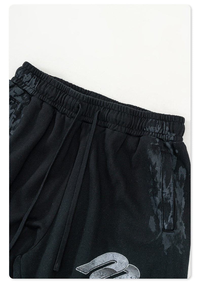 Detailed view of black Backstairs wide-leg sweatpants showing distressed paint effect and drawstring waistband detail