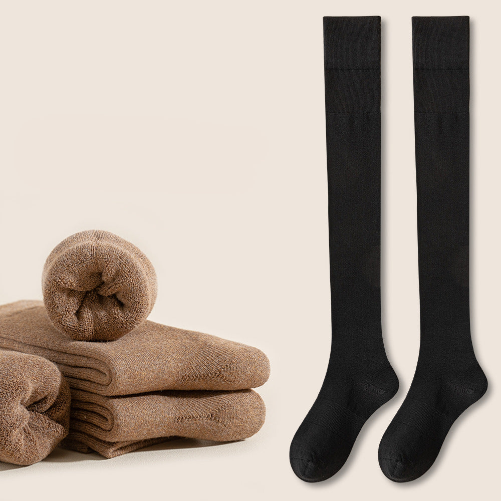 Black knee-high socks displayed with folded brown socks and red indicator button on beige background