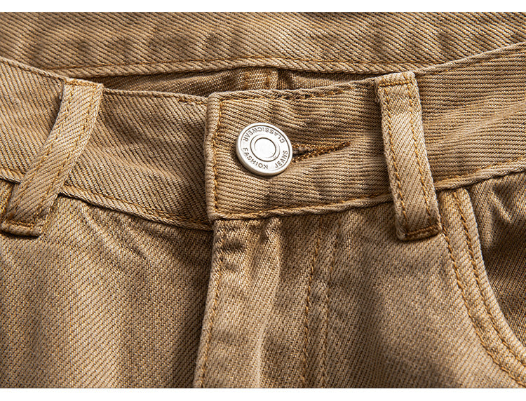 Close-up of tan wide-leg jeans waistband, showcasing button and pocket construction