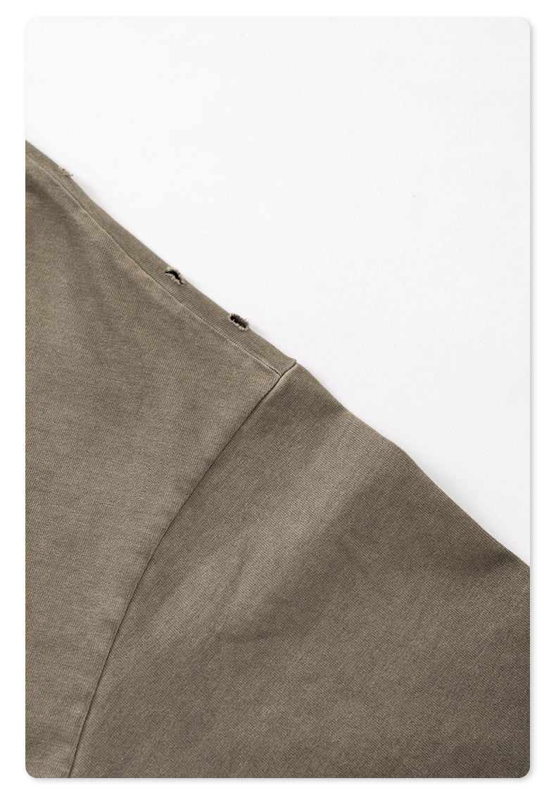 Detail of distressed seam construction on sleeve of taupe oversized t-shirt