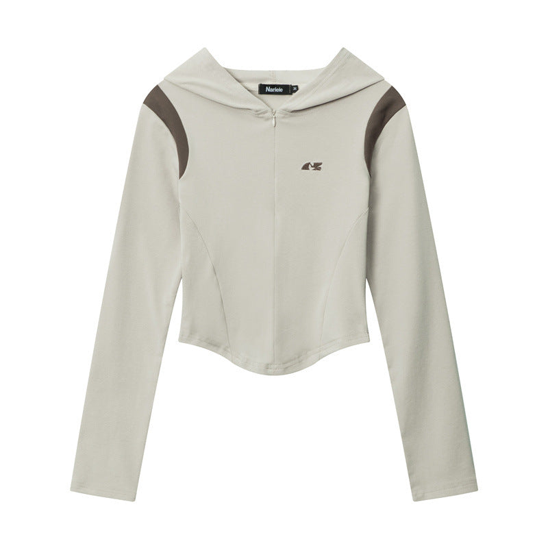 A beige cropped athletic hoodie with brown shoulder panels and small logo, photographed flat against white background