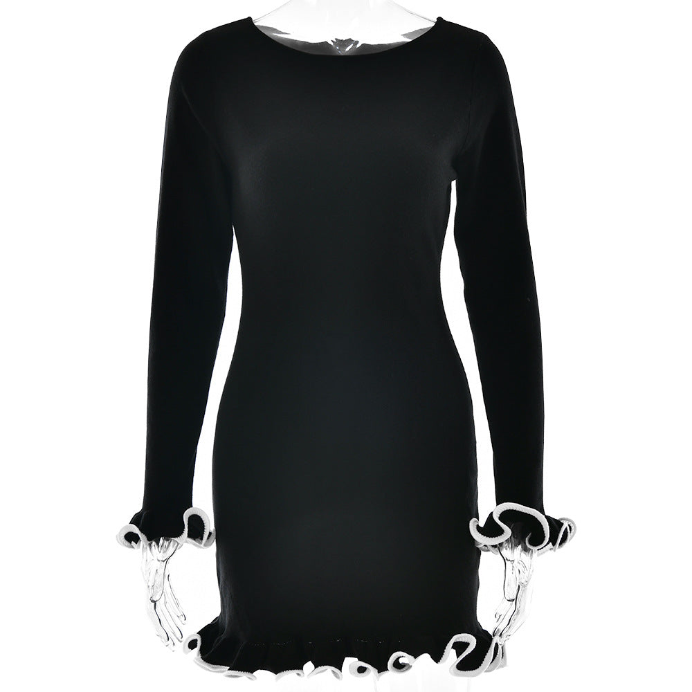Black fitted dress with white contrast ruffle trim shown on mannequin, featuring long sleeves and mini length