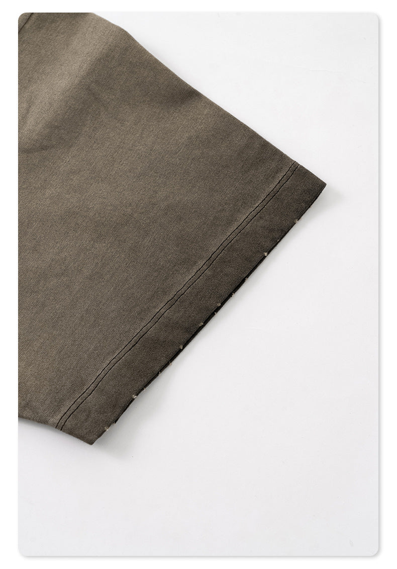 Close-up of taupe t-shirt hem showing double-needle stitching and raw edge distressing