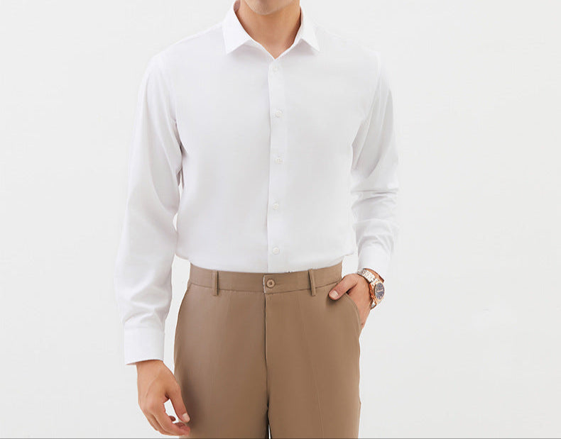 A model is wearing a crisp white dress shirt with khaki trousers. Gold watch visible on wrist as hand rests in pocket