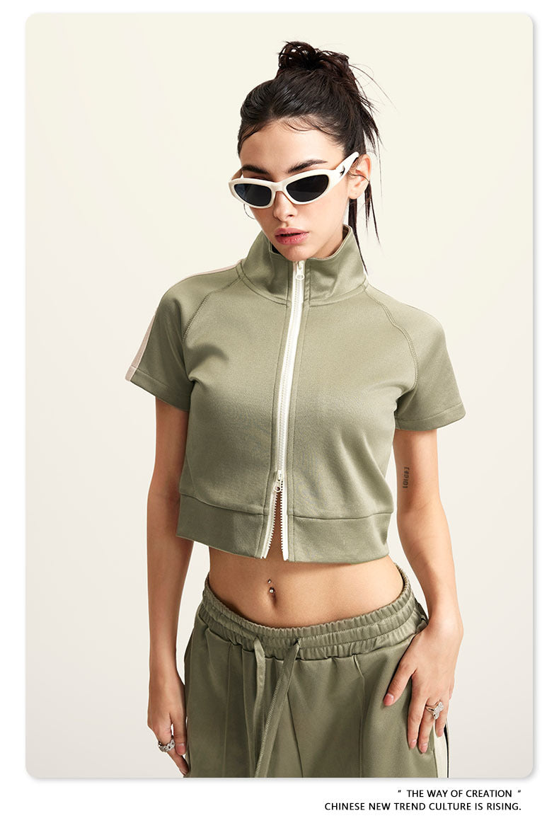 Light green crop top with white zip front, mock neck, short sleeves, white side stripes