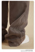 Close-up of grey sweatpants leg with textured ribbed side panel detail and white sneaker visible at bottom