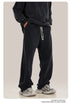 Person wearing black hoodie and navy blue sweatpants with white drawstring, showing side profile of the pants' fit