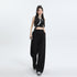 Model in black crop top with white trim and black wide-leg pants, wearing crossbody bag and platform sneakers