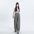 Model in white graphic print crop top and olive green wide-leg pants with elastic waist, styled with white platform shoes