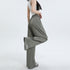 Side view of olive green wide-leg pants showing elastic waistband and flowing fabric, styled with white platform shoes