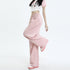 Close-up of pink wide-leg pants with elastic waist in motion, paired with a white star-print crop top and pink shoes
