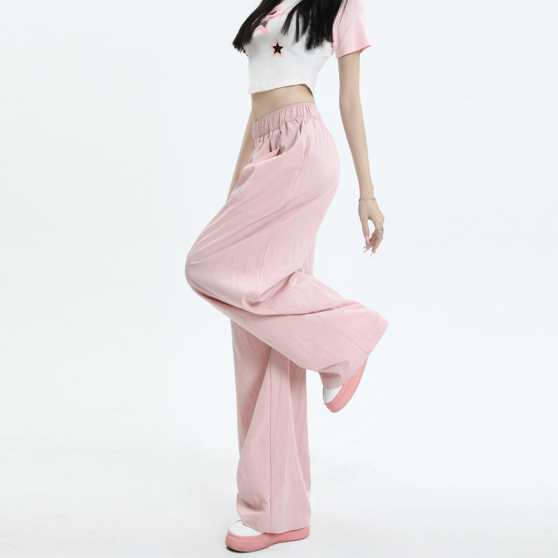 Close-up of pink wide-leg pants with elastic waist in motion, paired with a white star-print crop top and pink shoes