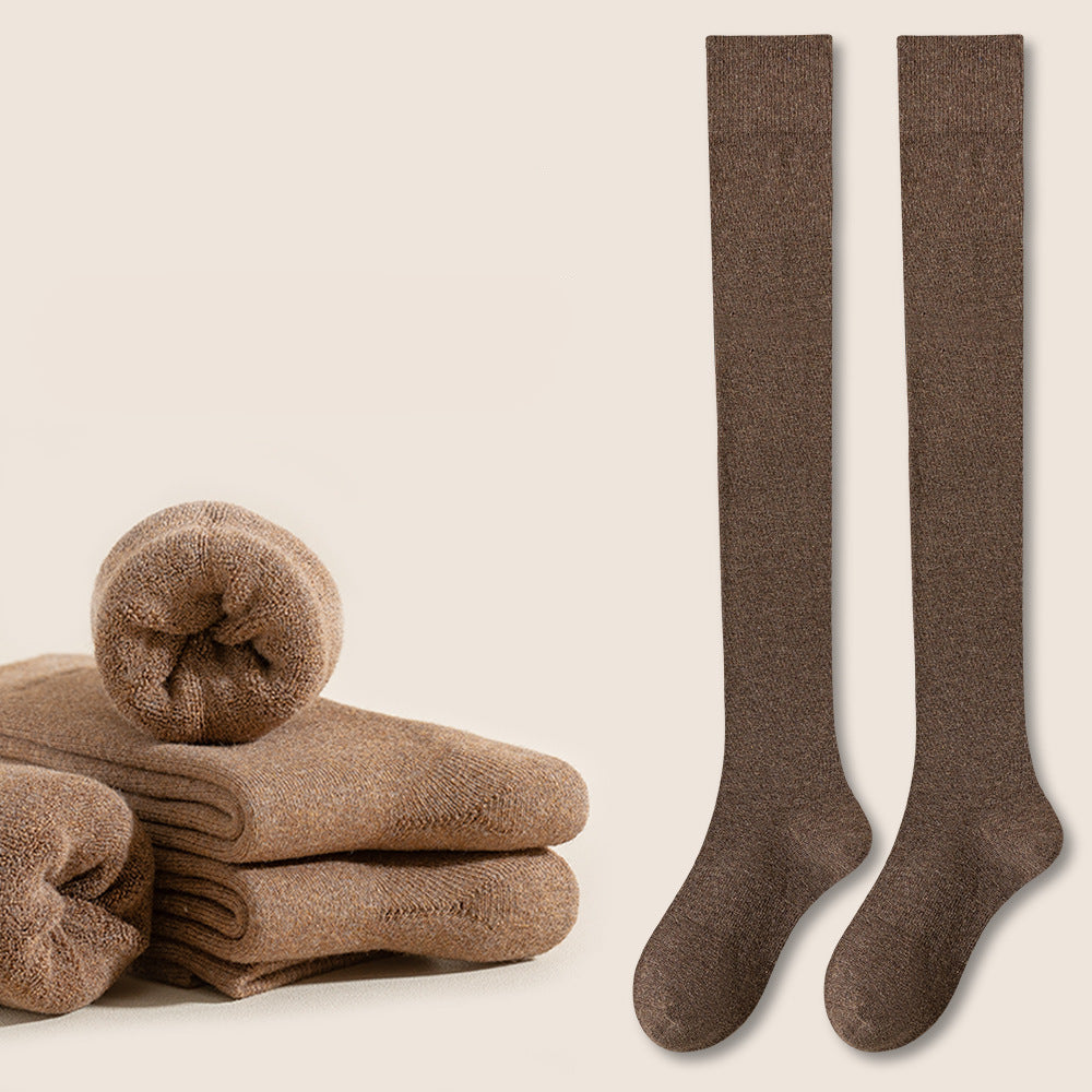 Brown knee-high socks displayed beside folded beige towels with red indicator button on left
