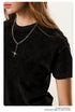 Close-up of black t-shirt neckline and silver chain necklace detail