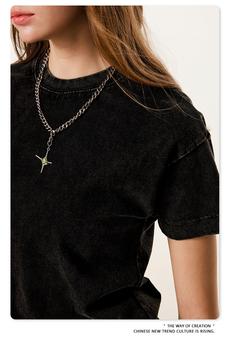 Close-up of black t-shirt neckline and silver chain necklace detail