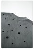 Close-up of paint splatter pattern on gray sweatshirt showing texture
