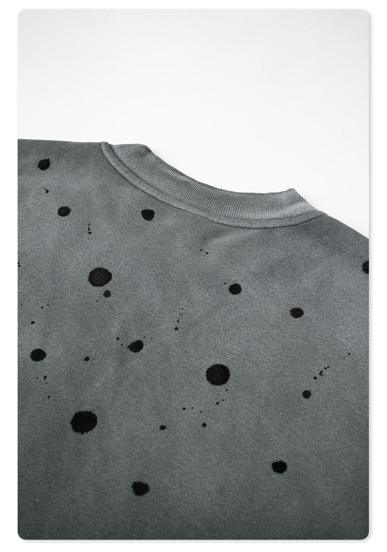 Close-up of paint splatter pattern on gray sweatshirt showing texture