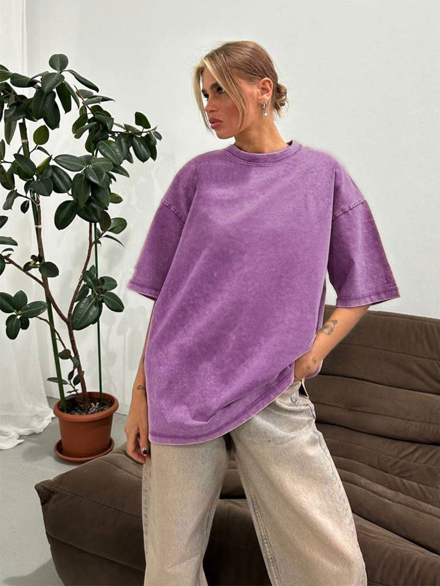 Person wearing an oversized purple shirt in a casual indoor setting