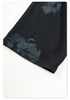 Distressed black Backstairs sweatpants fabric showing uneven paint effect pattern and texture details