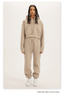 Beige Sweatshirt and Joggers Set – Model wears a warm beige hoodie and joggers with minimalistic sneakers