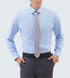 A model is wearing a light blue dress shirt with gray tie and charcoal trousers. Hands in pockets showing silver watch