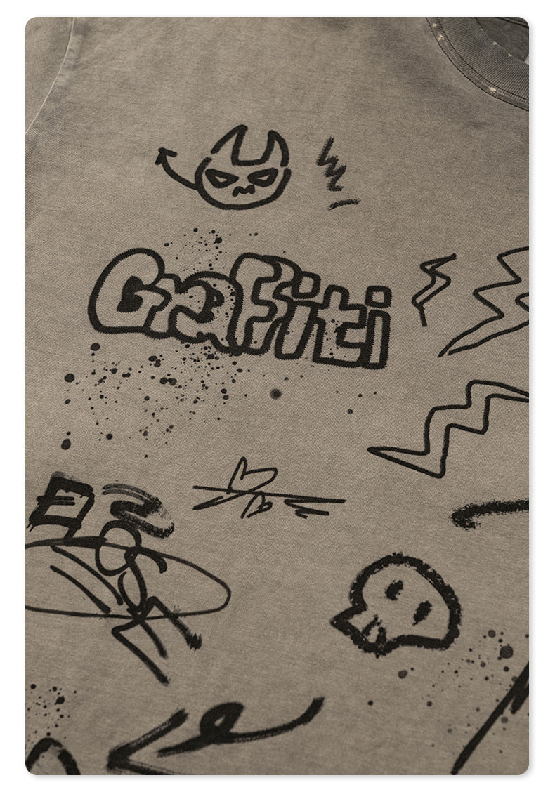 Detail view of graffiti artwork on t-shirt showing devil face icon and 'Graffiti' bubble lettering