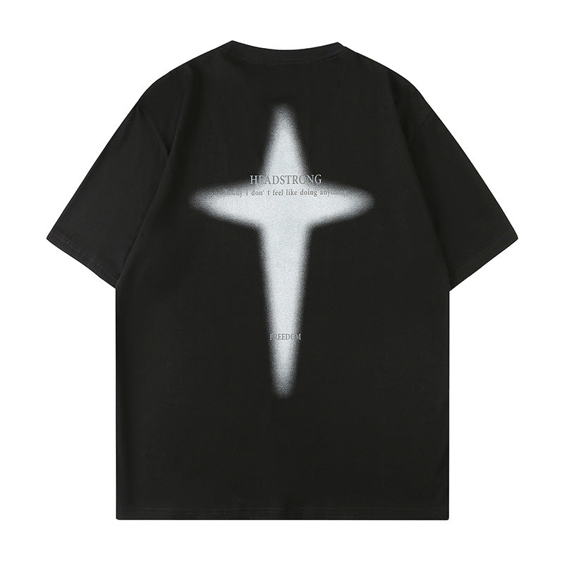 Black oversized tee displayed flat against white backdrop. Features white spray-painted cross graphic design with "HEADSTRONG" text overlay