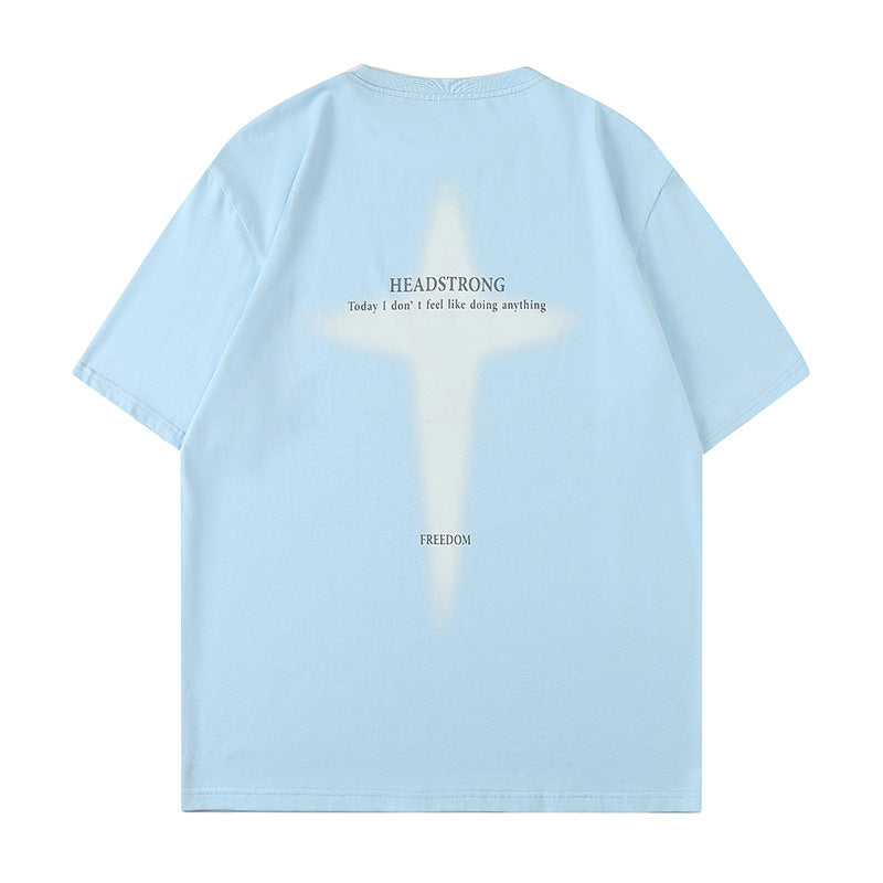 Light blue oversized tee displayed flat against white background. Features white cross graphic print with "HEADSTRONG" and "FREEDOM" text details