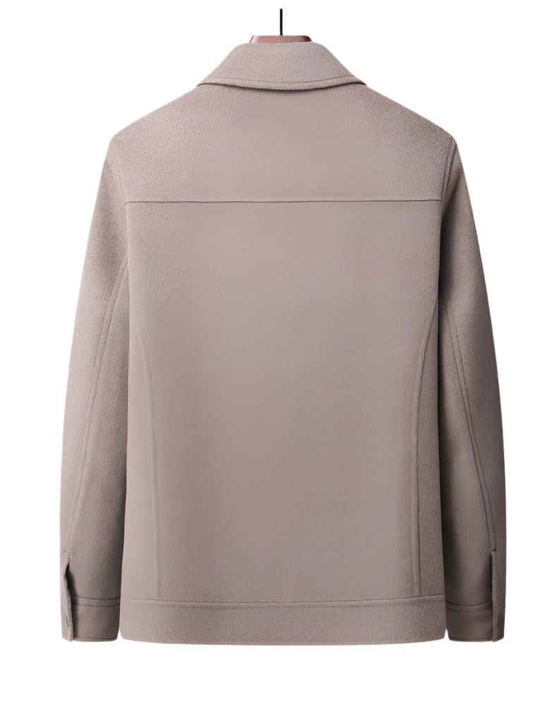 Back view of beige wool jacket on wooden hanger showing clean lines and tailored construction
