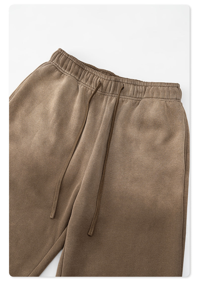 Detail of taupe sweatpants elastic waistband and drawstring against white background
