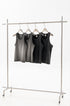 Four sleeveless tank tops in gray and black, displayed on a clothing rack with minimalist hangers