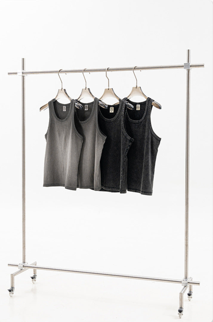 Four sleeveless tank tops in gray and black, displayed on a clothing rack with minimalist hangers