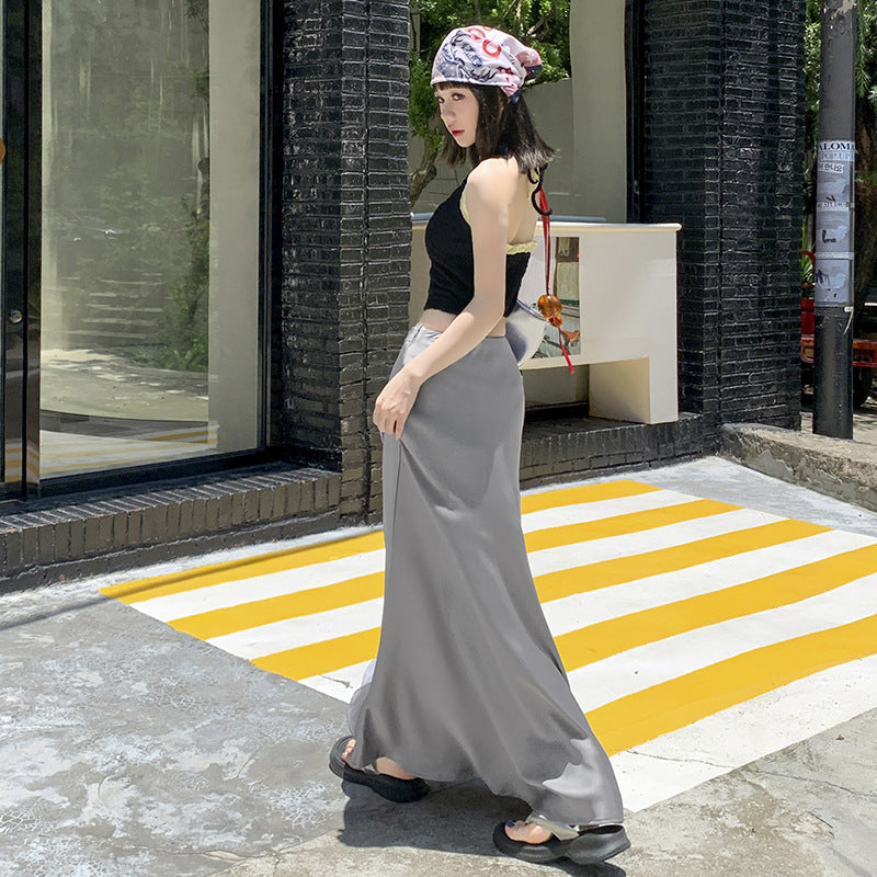 Same woman in similar outfit, viewed from a different angle on the yellow and white crosswalk