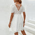 Back view of a white lace dress featuring an open-back tie detail and delicate eyelet embroidery, styled with gold accessories