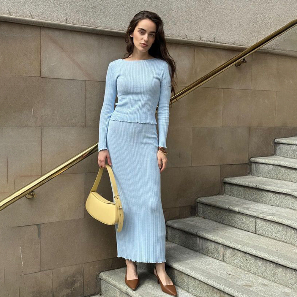 Light blue fitted ribbed dress with cream baguette bag against concrete staircase, minimalist urban fashion look