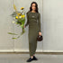 Olive green ribbed dress with sunflower bouquet and brown handbag, modern minimalist street style outfit