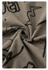 Twisted fabric detail showing drape and stretch quality of taupe cotton with black graffiti prints