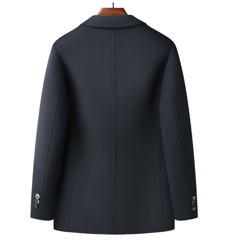 Back view of navy wool blazer on wooden hanger showing clean tailored lines and center vent